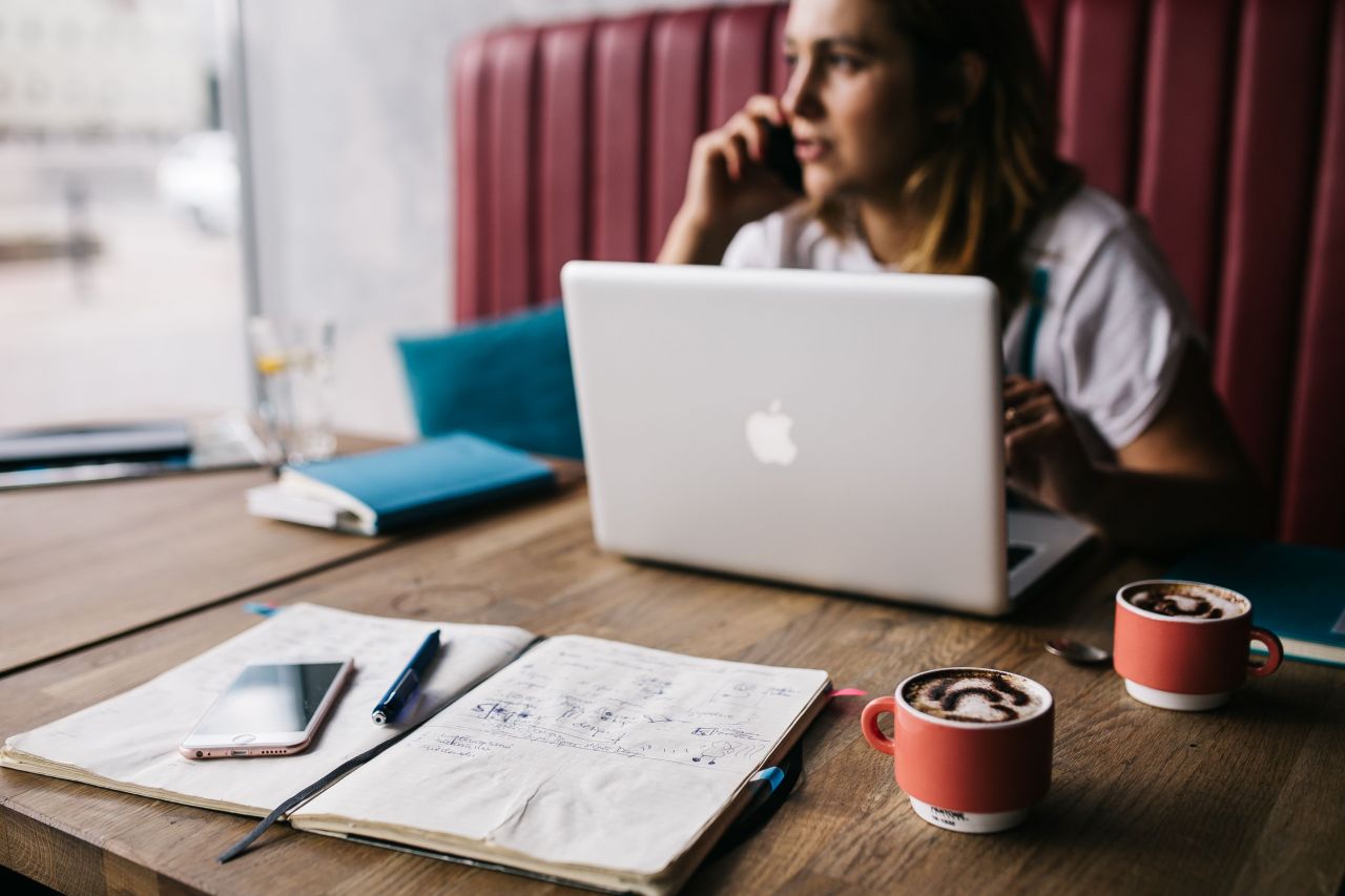 A woman working at her laptop in a cafe