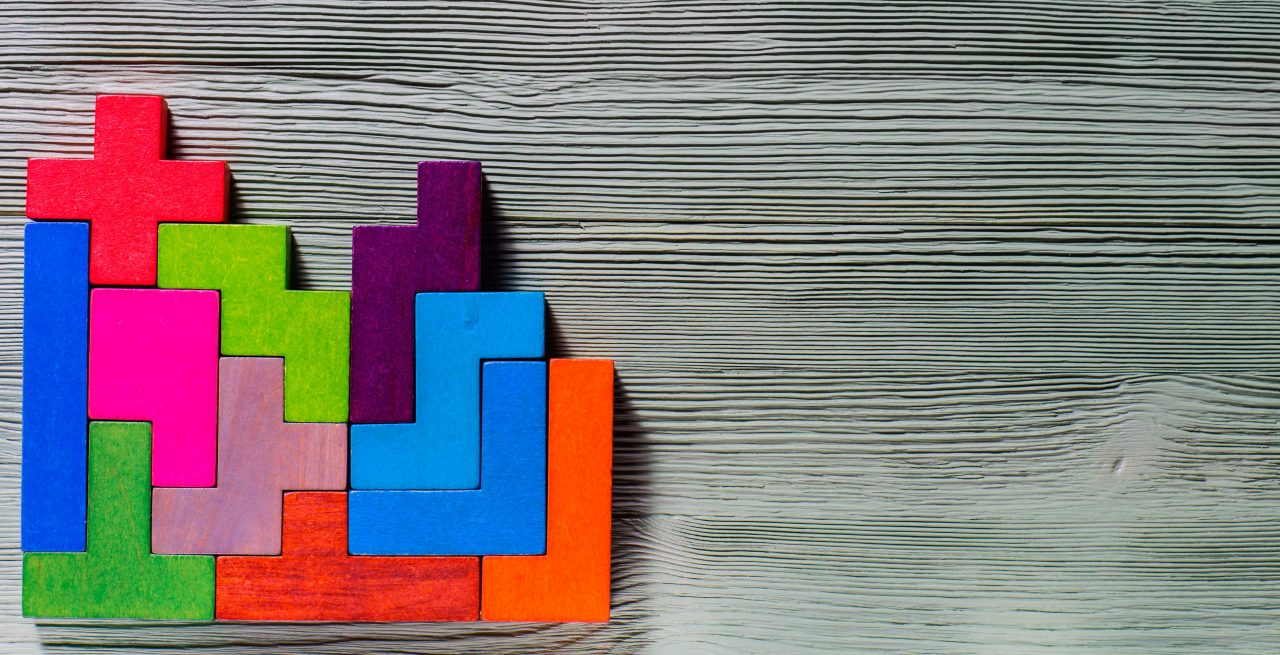 Brightly coloured geometric blocks on a wooden background