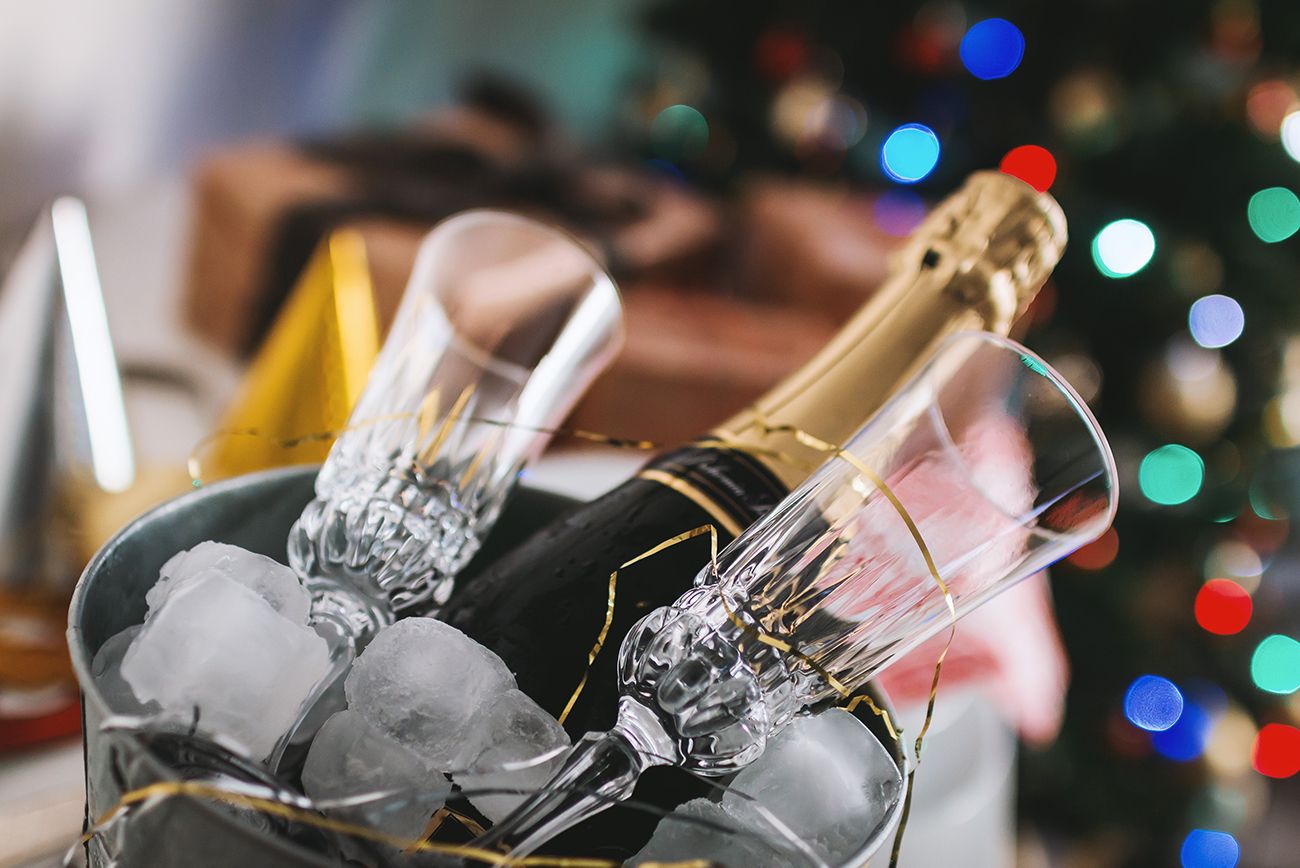 A bottle of champagne in an ice bucket, against a background of sparkling lights