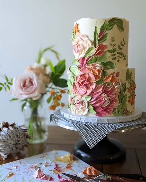 A gorgeous Sundbakes cake with pink flowers painted in buttercream.
